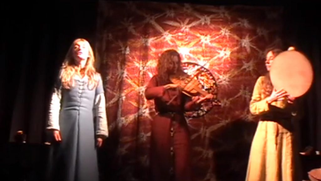 Fleurs de Lys playing Prendes i Garde, 13th century French carol (a danced song). The 4 string fiddle player, Helen Wilding, utilises the drone style suggested by the historical data; with Charlotte Bulley, lead voice and tambourine; and Anne-Marie Summers, tambourine, voice and bagpipes. Click on the picture to start the video, which opens in a new window.